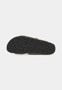 Semelle de sandale marron avec une base en caoutchouc noir texturée, présentant un motif géométrique d'étoiles. Design léger avec une forme simple.