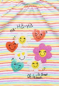 Bunt gestreifter Stoff mit gestickten Blumen und Herzen, der lächelnde Gesichter und Pailletten zeigt. Text beinhaltet "Ha-Ha-Ha" und "So süß."