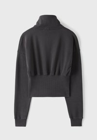 Sweat-shirt court noir à manches longues avec col montant et ourlet et poignets côtelés, vu de dos sur un fond uni.