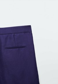Violett, skräddarsydda byxor med platt midja och en bakficka, tillverkade av ett slätt tyg med en subtil lyster.