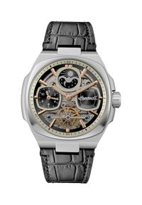 Automatisch horloge met een kast van roestvrij staal, zwarte krokodillenleren band, zilveren en gouden accenten, en een transparante wijzerplaat die ingewikkelde mechanismen onthult.
