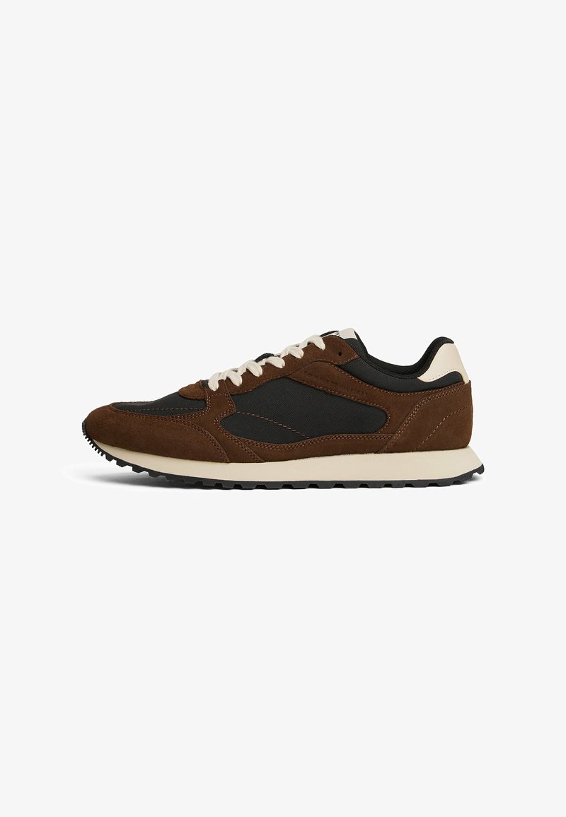 Braune Wildleder- und schwarze Baumwollsneaker mit einer beigen Sohle, ausgestattet mit strukturierten Akzenten und weißen Schnürsenkeln für ein retro-inspiriertes Design.