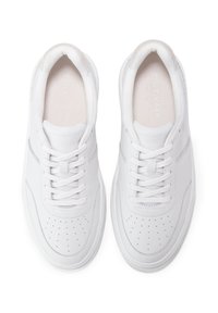 Weiße Sneaker mit einer glatten Lederoberfläche, perforierter Zehenpartie, flachen weißen Schnürsenkeln, gepolstertem Schaft und einem minimalistischen Design.