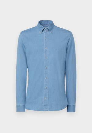 Ljust blå denimskjorta med långa ärmar, knapp-down krage och framknäppning. Har en diskret broderad logotyp på bröstet.