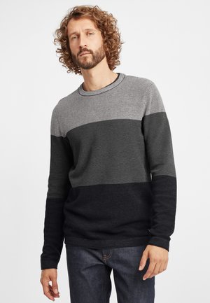 Strikket sweater i grå, mørkegrå og marineblå striber. Har en rund halsudskæring og tekstureret stof. Bæres med mørke jeans.