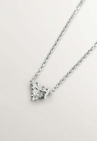 Collar de cadena de plata con tres piedras, una redonda más grande y dos más pequeñas, dispuestas en un diseño estructurado. Textura suave con un acabado pulido.