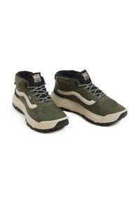 Green high-top sneakers with a textured upper, padded collar, and white accents. Features dark laces and a rugged black sole for traction.