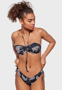 Bikini bandeau negro con estampado de animal; cuenta con fruncidos en la parte superior, tiras delgadas y un fondo de cintura baja con acentos laterales.