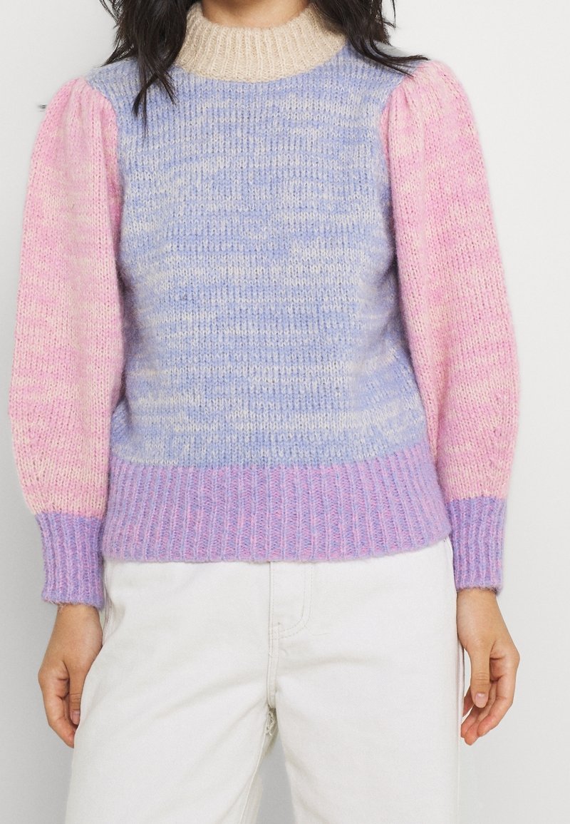 Pull en tricot présentant un dégradé pastel avec des manches bouffantes texturées en rose clair et bleu, ainsi qu'un col et un ourlet côtelés.