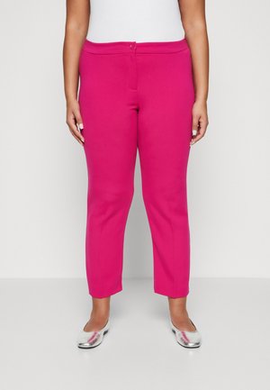 Fuchsia pink cropped trousers with a smooth texture, button closure, and a fitted waist. Worn with silver ballet flats.