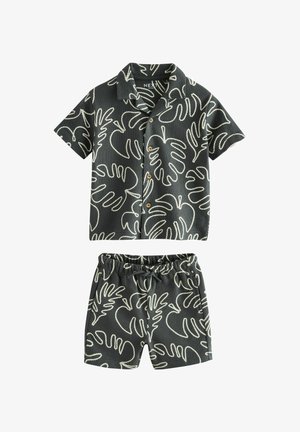 Black short-sleeve button-up shirt and shorts set with white tropical leaf outlines, elastic waistband shorts with drawstring.