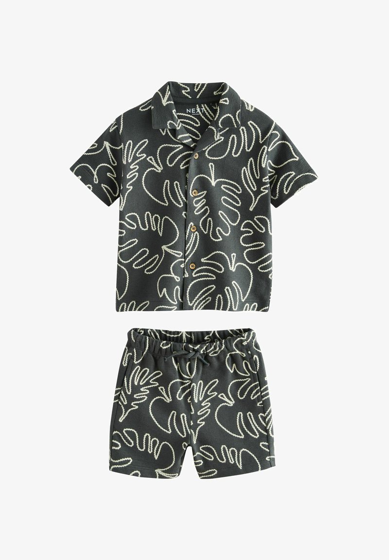 Ensemble composé d'une chemise noire à manches courtes avec boutons et d'un short, orné de contours blancs de feuilles tropicales, short avec taille élastique et cordon de serrage.