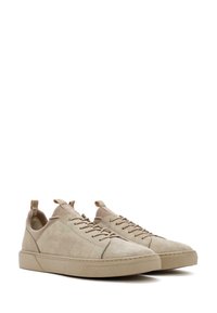 Sneakers in suede beige con profilo basso, punta arrotondata e suola in gomma piatta. Presentano chiusura con lacci e linguetta sul tallone.