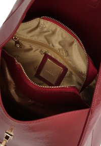 Borsa a mano rosso intenso con esterno lucido, ferramenta dorata e cerniera. Interno con fodera liscia e brillante color oro e tasca con cerniera.