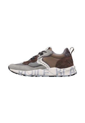 Seitenansicht eines niedrig geschnittenen Sneakers mit grauen, braunen und weißen Paneelen und einer dicken weißen Sohle mit großem aufgedrucktem Text.