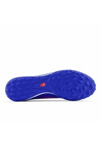 Sport shoe sole in blue rubber, featuring textured, circular patterns for grip; white side accents and a logo in red on the arch.