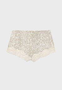Shorts blancs avec bordure en dentelle couverts de sequins argentés verticaux, posés à plat sur un fond gris clair.