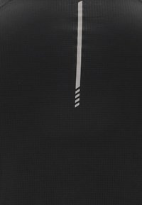 Tissu noir texturé avec une bande réfléchissante verticale se terminant par trois barres diagonales près du bas au centre.