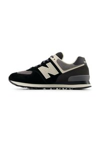 Sneaker nero e grigio realizzata in materiali scamosciati e in mesh, con un prominente logo "N" bianco, punta rotonda e suola in gomma texturizzata.