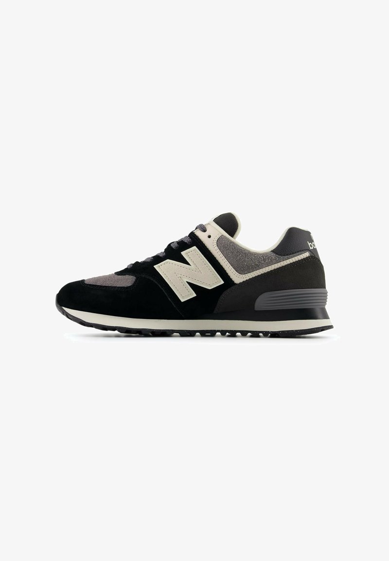 Black and grey sneaker with suede and mesh materials, featuring a prominent white "N" logo, round toe, and textured rubber sole.