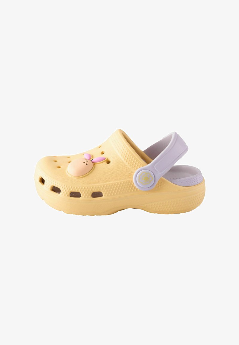Sabot jaune à enfiler avec une bride blanche réglable au talon et une petite décoration lapin rose sur le devant supérieur.