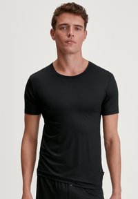 Black, short-sleeve t-shirt made of smooth, lightweight fabric with a round neckline. Features a fitted design with subtle stitching.