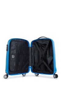 Valise rigide bleue avec une ouverture zippée, dotée d'un intérieur noir doublé, de sangles croisées et de plusieurs compartments. Roues et poignée incluses.