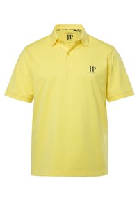 Gul polo shirt lavet af bomuld med en klassisk krave, tre-knap lukning og et lille sort logo "JP 1880" på venstre bryst.
