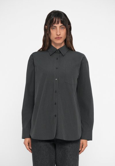 Chemise à boutons gris foncé avec des rayures blanches verticales, manches longues, col et détail de poche sur le côté gauche.