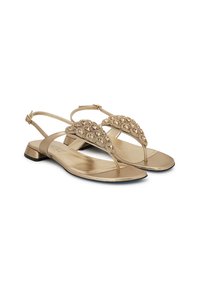 Sandali metallici dorati con tacco piatto, caratterizzati da un design a infradito e un upper decorato con strass. Inclusa una cintura regolabile per il tallone.