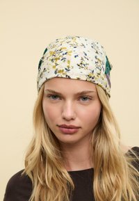 Écharpe à motifs floraux avec des nuances de blanc, jaune, rose et vert. Fabriquée en tissu doux, elle présente un design patchwork multicolore.