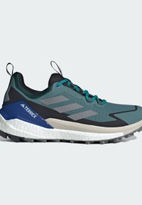 Trail running shoes featuring a turquoise upper, black accents, and gray stripes. The sole has white cushioning and a rugged pattern for traction.