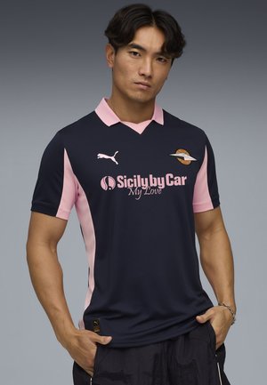Camiseta azul marino con detalles en rosa, que incluye un cuello, el logo de Puma y marcas de patrocinio. Confeccionada con tela transpirable, ajuste casual.