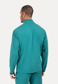 Türkisfarbener Pullover mit langen Ärmeln und hohem Kragen. Hergestellt aus glattem, dehnbarem Stoff. Verfügt über schwarze Akzente an den Manschetten und am Saum.