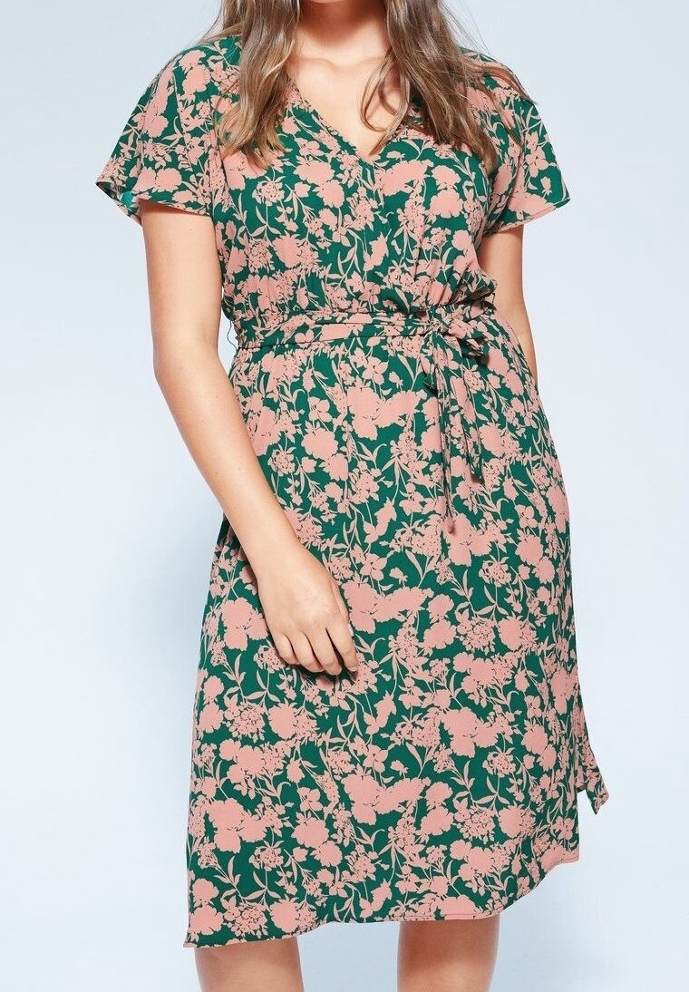 Vestido de corte envolvente en tejido verde con flores rosas. Cuenta con mangas cortas, un escote en V y un cinturón en la cintura para un ajuste ceñido.