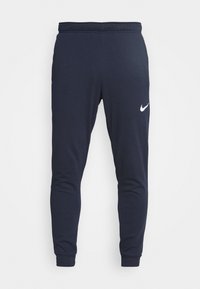 Námořnické modré sweatpants ze směsi bavlny s tapered fit, nastavovací páskou v pase a bílým logem Nike na levém stehně.