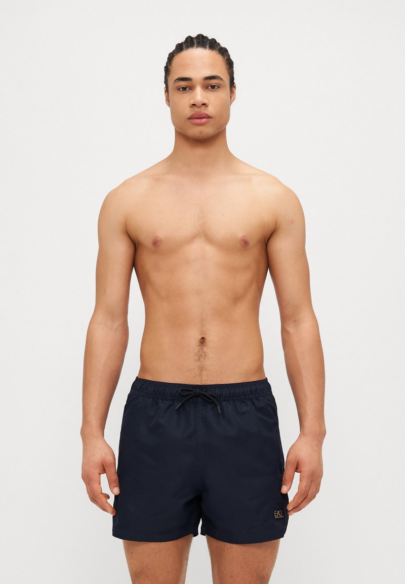 Shorts de bain navy en tissu léger avec une taille élastique et un cordon de serrage, ornés d'un petit logo sur le devant.