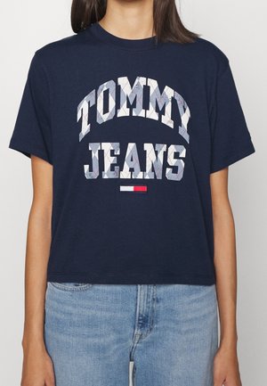 Marineblå bomulds t-shirt med "TOMMY JEANS" logo i et mønstret skrifttype. Korte ærmer, rund hals og en let kortet pasform.