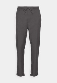 Pantaloni grigi con vita a cordoncino elastico, design a gamba affusolata e orli arrotolati. Il tessuto appare liscio con una texture sottile.