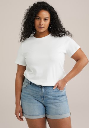 Witte katoen T-shirt met korte mouwen, gecombineerd met lichtblauwe denim shorts. De shorts hebben een opgerolde zoom en een zijzak.