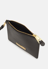 Svart läderclutch med guldfärgad hårdvara, dragkedjestängning och präglad logotyp på framsidan. Utrustad med en handledsrem för enkel bärning.