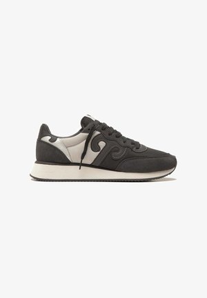 Sneakers da uomo realizzati in materiali sintetici neri e grigi, con una finitura in tessuto liscia, punta tonda e un design ondulato a contrasto ai lati.