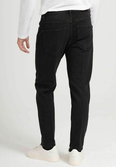 Zwarte denim jeans met een slim fit, voorzien van achterzakken en een recht gesneden pijp. G dragen met witte sneakers en een lange mouw shirt.
