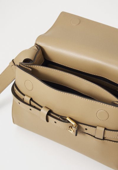 Beige leather handbag with a structured shape, featuring a top flap, strap, and gold hardware accents. Interior reveals multiple compartments.