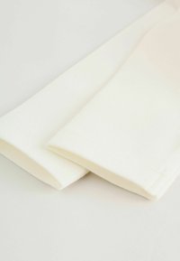 Baltos medvilninės rankovės su lygiu paviršiumi, švariu apačios siūlėliu ir subtiliais ribotais manžetais, išdėstytos ant šviesaus fono.