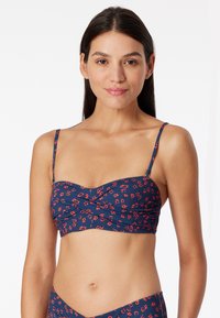 Marine bikini top met bloemenpatroon, verstelbare banden, geplooid ontwerp en een aansluitende pasvorm. Gemaakt van lichtgewicht stretchmateriaal.