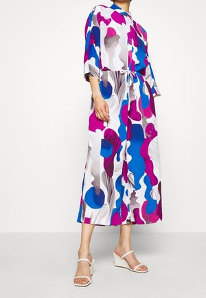 Robe longue à motifs avec des formes audacieuses en rose, bleu et gris. En tissu léger, elle possède une taille ceinturée et des manches trois-quarts.