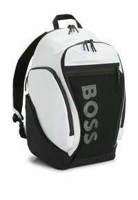 Svart och vit ryggsäck med en stilren design, med mesh-accenter, flera dragkedjefack och "BOSS"-logotyp på framsidan.