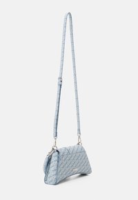 Sininen olkalaukku, jossa on kolmion muotoinen muoto ja valkoinen tekstikuvio koko pinnalla. Hihna on säädettävissä, ja siinä on hopeanvärisiä metalliosia.