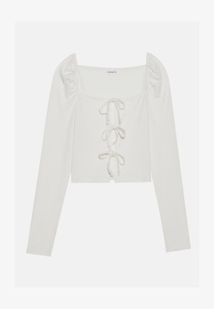 T-shirt blanc à manches longues côtelées, avec un décolleté carré, des manches bouffantes et un détail de laçage à l'avant avec des liens fins. Design court.